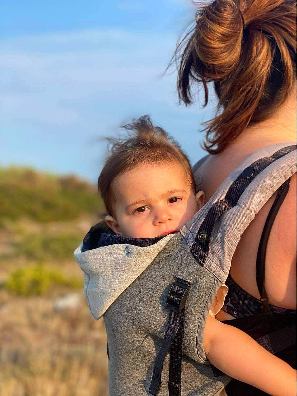 Thëa participe au concours pour gagner de l'argent avec cette photo : baby, brown_hair, child, cloud, face, facial_expression, fun, grass, happy, jewellery, leisure, people_in_nature, person, red_hair, rock, sitting, skin, sky, toddler, tree