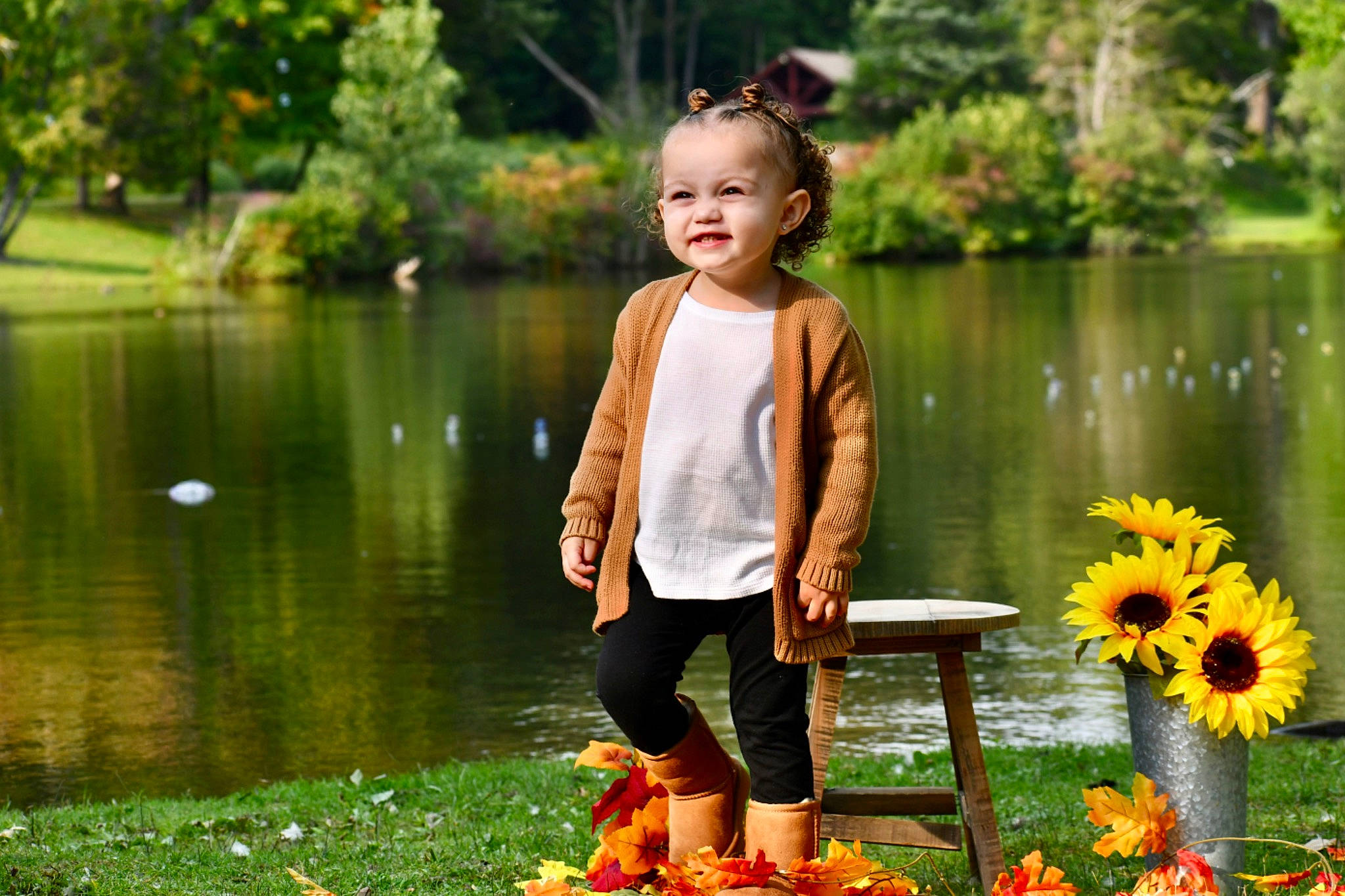 Amina is registered to the contest to win money with this photo: baby_toddler_clothing, botany, facial_expression, flower, fun, grass, happy, joy, lake, leaf, leisure, nature, people_in_nature, person, petal, photograph, plant, shorts, toddler, tree