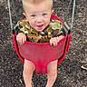 toddler, child, swing, playground, red_swing, blue_eyes, barefoot, smiling, tongue_out, short_hair, mohawk, outdoor, play, fun, young_child, person, seat, ground, metal_chains, casual_clothing