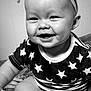 baby, smiling, face, headband, bow, stars, clothing, infant, cheeks, teeth, black_and_white, indoor, cute, happy, person, closeup, sitting, arm, mouth, portrait