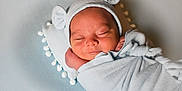 Jakhari is registered to the contest to win money with this photo: newborn, baby, sleeping, swaddled, blanket, hat, bear_ears, cushion, pom_pom, soft_texture, peaceful, infant, portrait, indoors, cute, resting, child, wrapped, cozy, head