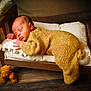 Jakhari is registered to the contest to win money with this photo: newborn, baby, sleeping, knitted_outfit, wooden_bed, cushion, teddy_bear, floor, cozy, cute, infant, portrait, indoor, child, soft_lighting, peaceful, resting, hand, face, fur
