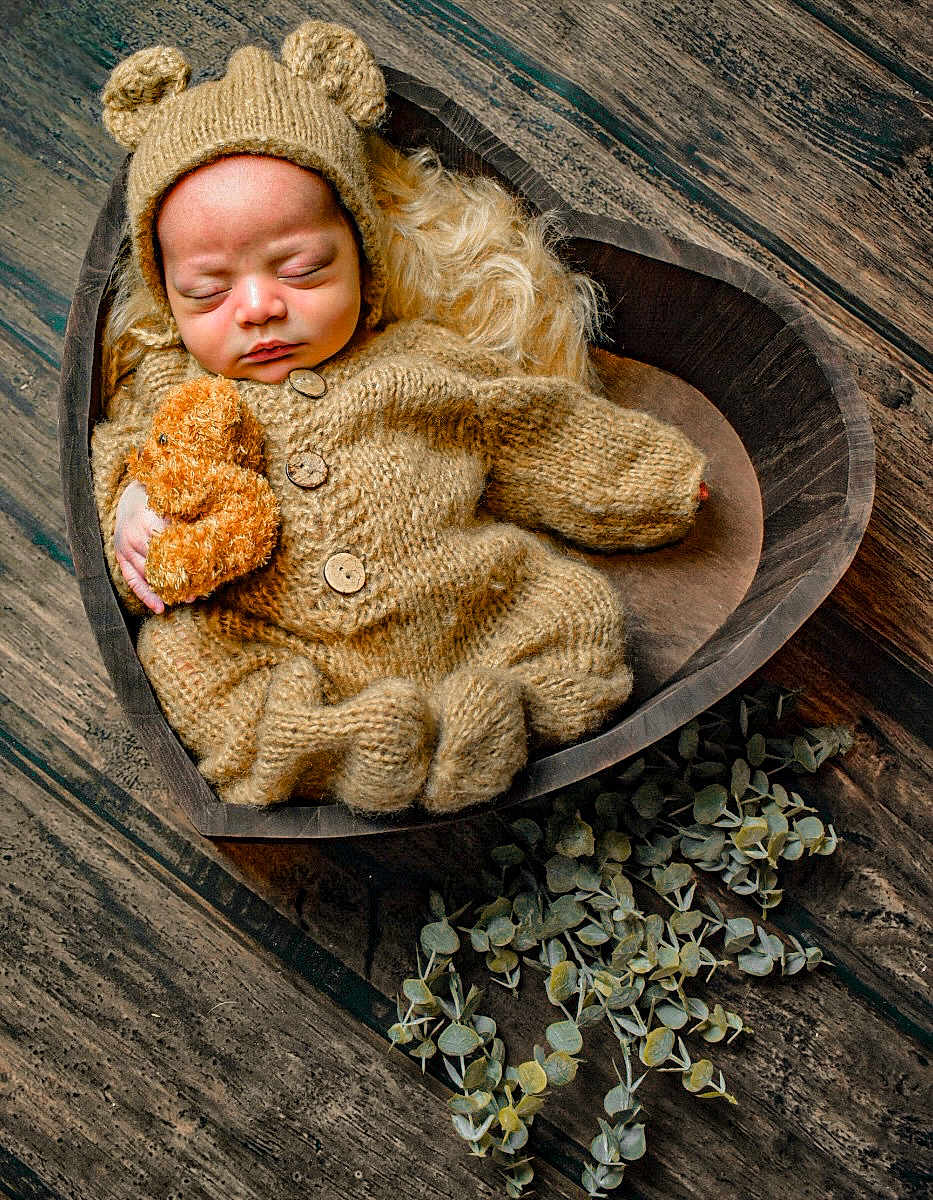 Jakhari joined the competition — help win amazing prizes! baby, newborn, sleeping, knitted_clothing, bear_outfit, teddy_bear, heart_shaped_bowl, wooden_floor, greenery, cozy, cute, infant, portrait, soft_lighting, handmade, warm_colors, resting, child, adorable, peaceful