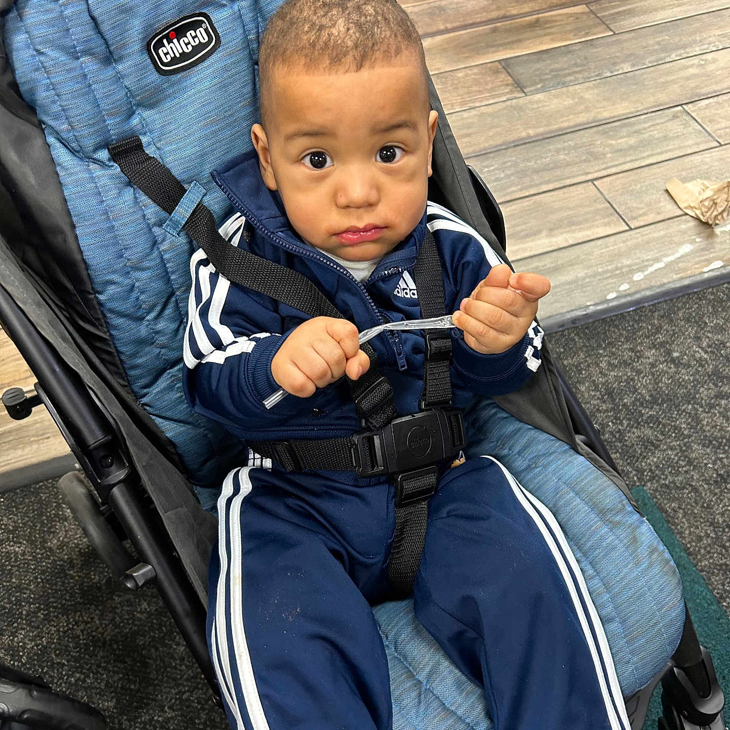 Messiah is registered to the contest to win money with this photo: bodypart, boy, child, clothing, coat, cutlery, face, finger, footwear, hand, head, jacket, male, pants, person, photography, portrait, shoe, spoon, stroller