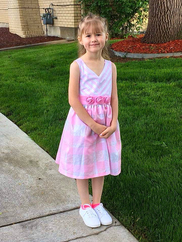 Karissa is registered to the contest to win money with this photo: baby_toddler_clothing, day_dress, dress, face, fun, grass, grass_family, head, joy, lawn, leg, leisure, magenta, pattern, people_in_nature, person, pink, plant, public_space, smile