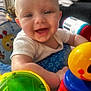 Bohdi is registered to the contest to win money with this photo: baby, child, smiling, toy, play, indoor, happy, face, arm, colorful, music_notes, plastic_toy, seat, cushion, person, closeup, infant, expression, bright, warm_light