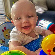Bohdi is registered to the contest to win money with this photo: baby, smiling, happy, child, toys, colorful, indoor, infant, face, closeup, playtime, cute, bright, cheerful, person, young, skin, expression, seat, daylight