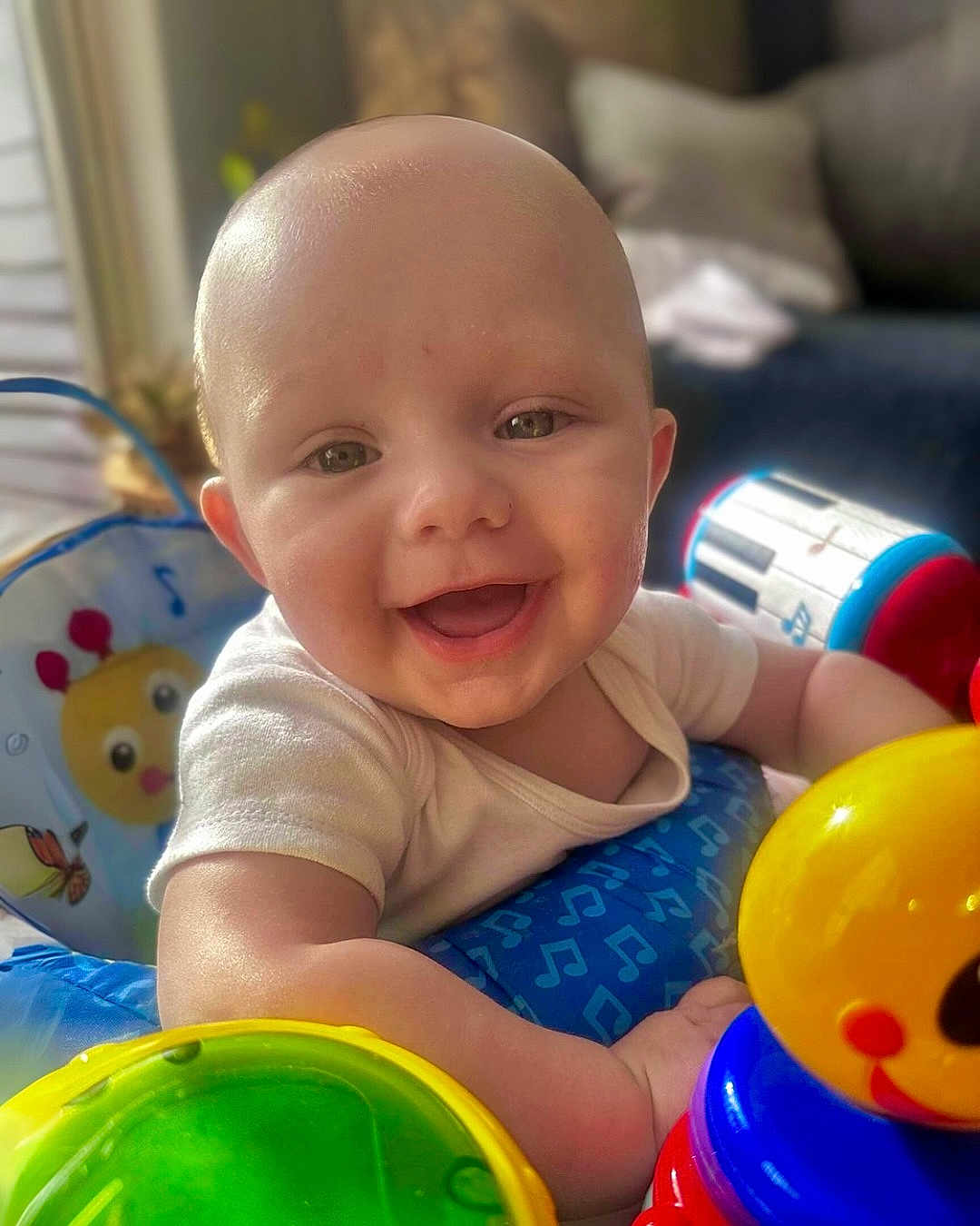 Bohdi is registered to the contest to win money with this photo: baby, smiling, happy, child, toys, colorful, indoor, infant, face, closeup, playtime, cute, bright, cheerful, person, young, skin, expression, seat, daylight