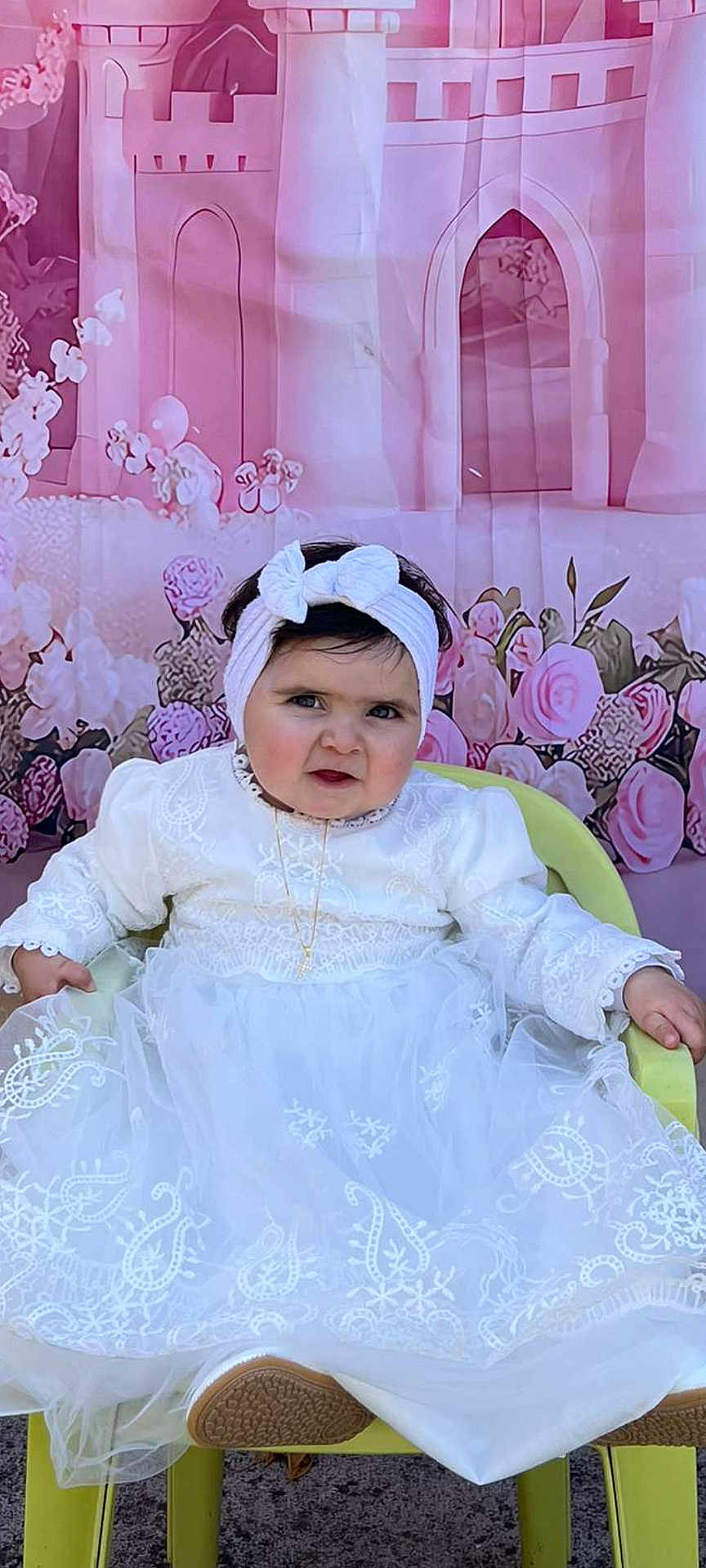 Valentina participe au concours pour gagner de l'argent avec cette photo : baby, child, white_dress, headband, chair, pink_backdrop, castle, flowers, portrait, sitting, cute, indoor, decor, person, happy, fashion, toddler, costume, celebration, smile