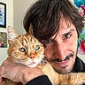 Roucky a rejoint le concours — aidez-le/la à gagner de superbes lots ! affection, animal, artwork, background, cat, closeup, clothing, expression, eyes, face, fur, hand, human, indoor, man, orange_tabby, pet, portrait, selfie, wall