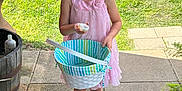 Tinley is registered to the contest to win money with this photo: barrel, basket, casual, child, daylight, expression, footwear, girl, grass, happy, holding, nature, outdoor, pink_dress, plant, sandals, sidewalk, summer, wooden_porch, young