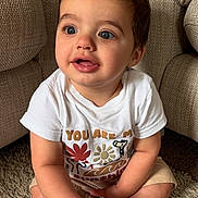 Zak joined the competition — help win amazing prizes! toddler, child, baby, sitting, carpet, couch, white_tshirt, shorts, indoor, cute, blue_eyes, curly_hair, expression, hands, legs, smile, plush_furniture, casual_clothing, portrait, young