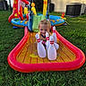 Cain is registered to the contest to win money with this photo: backyard, blue, bowling_pins, child, curly_hair, fun, grass, green, inflatable, outdoor, play, red, smile, summer, sunlight, toddler, toy, water, water_slide, yellow