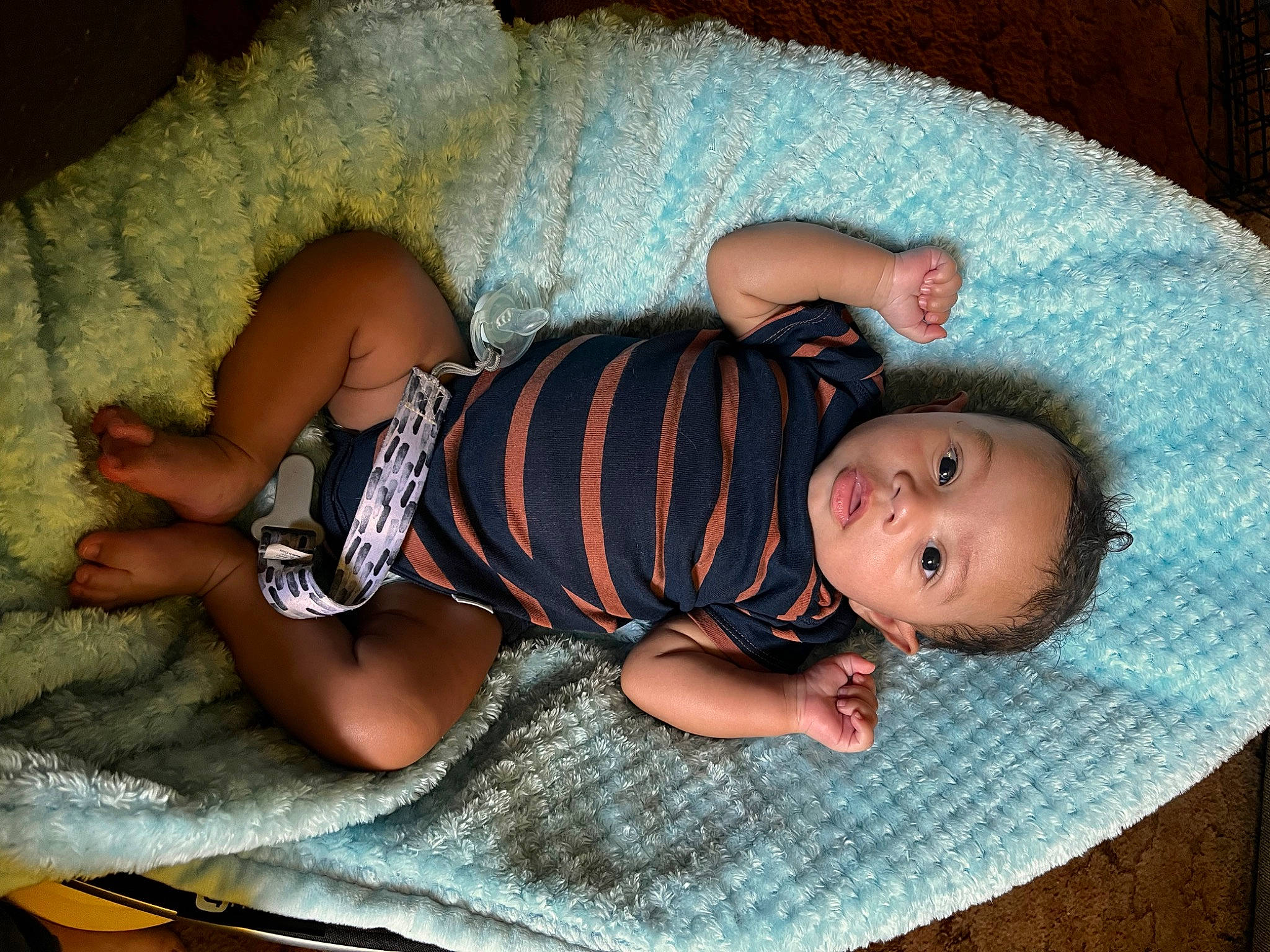 Jakai is registered to the contest to win money with this photo: baby, baby_products, baby_toddler_clothing, child, comfort, eye, flooring, head, headgear, human_body, linens, mammal, pattern, person, room, sitting, skin, sleeve, textile, toddler