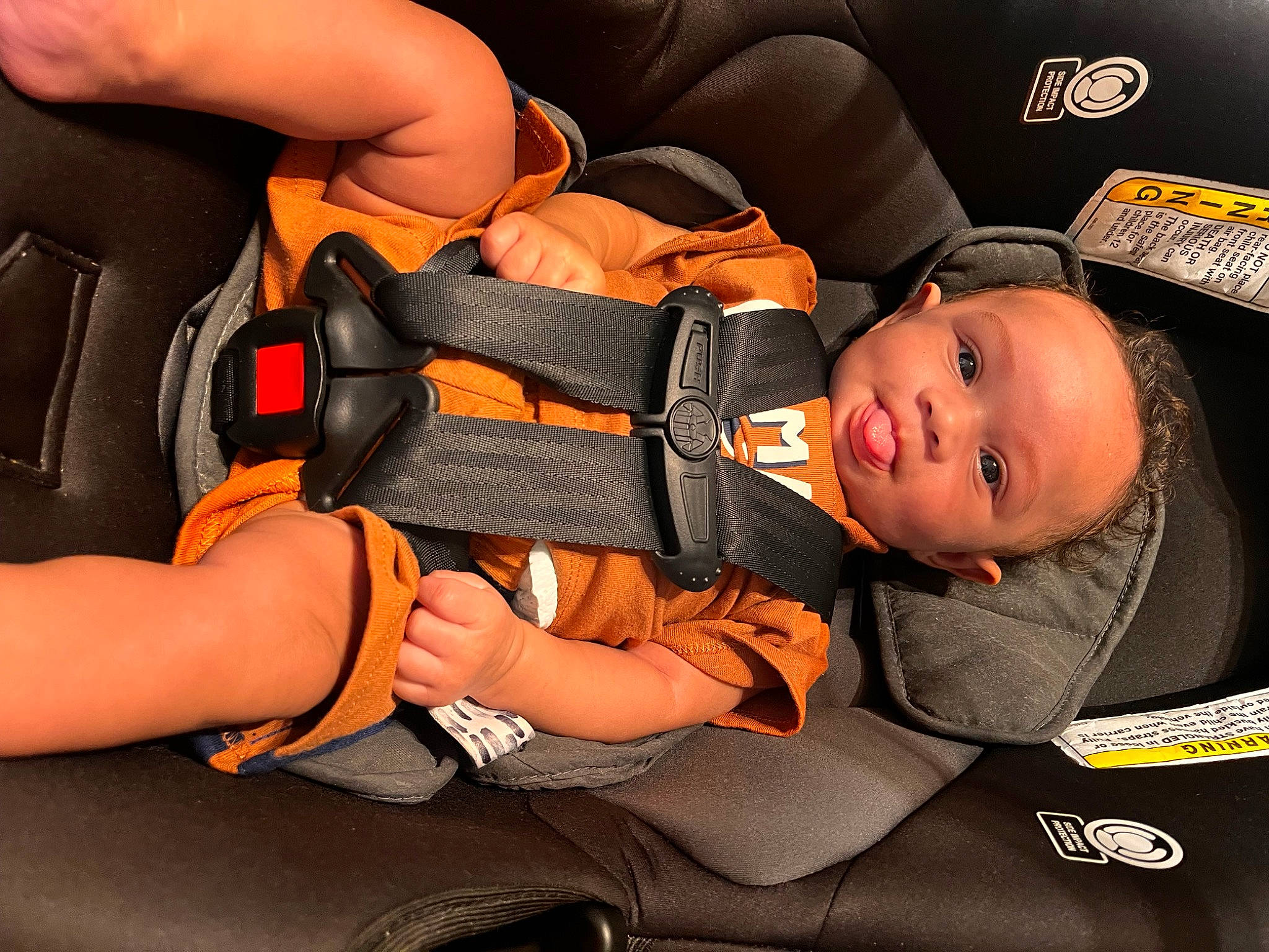 Jakai is registered to the contest to win money with this photo: auto_part, automotive_design, baby, baby_carriage, baby_in_car_seat, baby_products, baby_toddler_clothing, car_seat, car_seat_cover, child, comfort, finger, orange, person, personal_protective_equipment, product, seat_belt, sitting, thigh, toddler