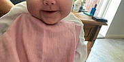 Larosa is registered to the contest to win money with this photo: baby, smiling, pink_blanket, indoor, face, child, table, flowers, vase, cozy, person, happy, portrait, couch, furniture, soft_light, cute, infant, family, home