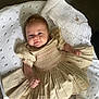 Larosa is registered to the contest to win money with this photo: baby, infant, dress, beige, blanket, knitted, white, smile, face, cute, child, lying, fabric, cozy, soft, indoors, person, newborn, clothing, portrait