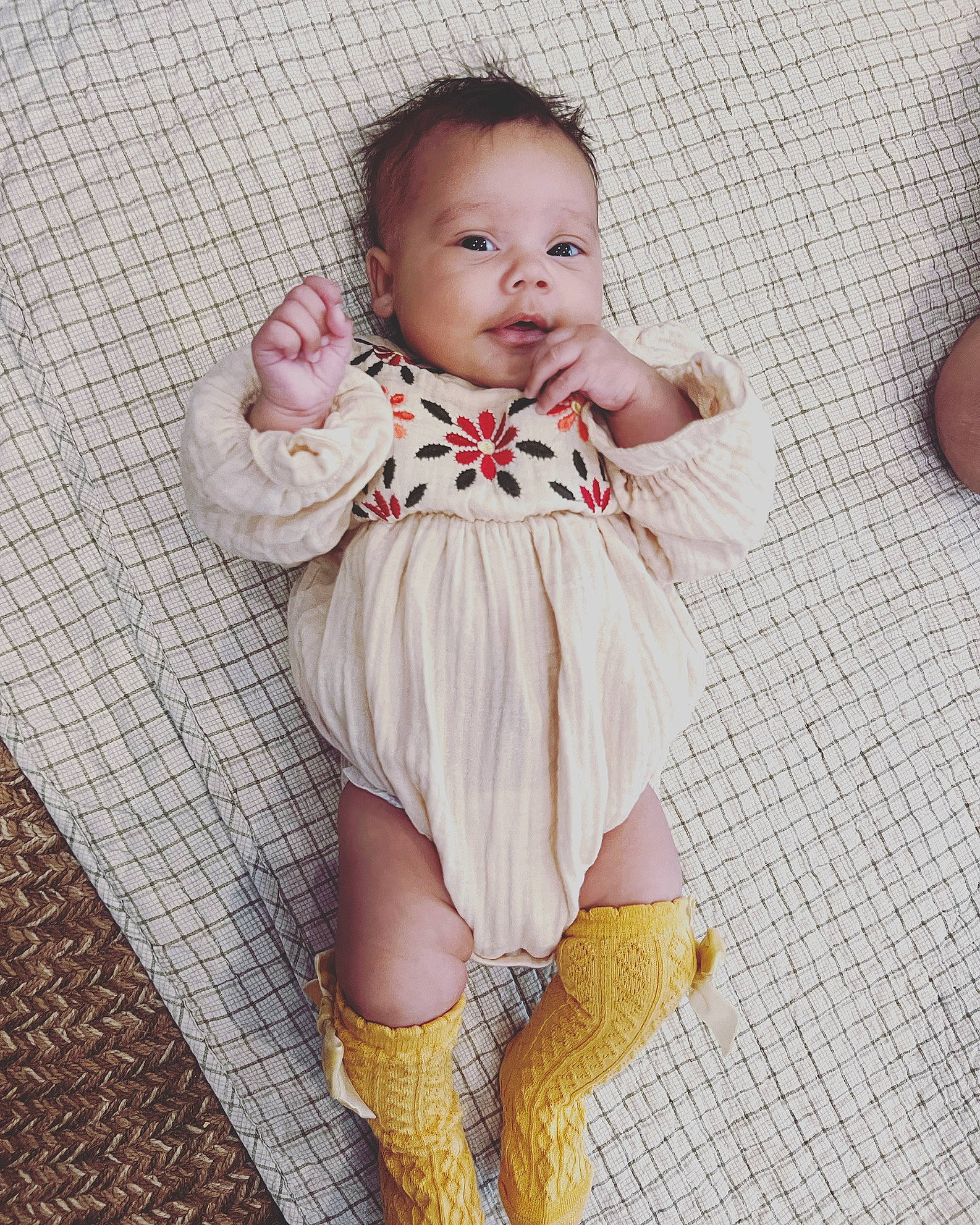 Sol Grace is registered to the contest to win money with this photo: arm, baby, baby_toddler_clothing, day_dress, dress, eye, face, finger, hand, head, knee, one_piece_garment, pattern, person, skin, sleeve, smile, sock, thigh, toddler