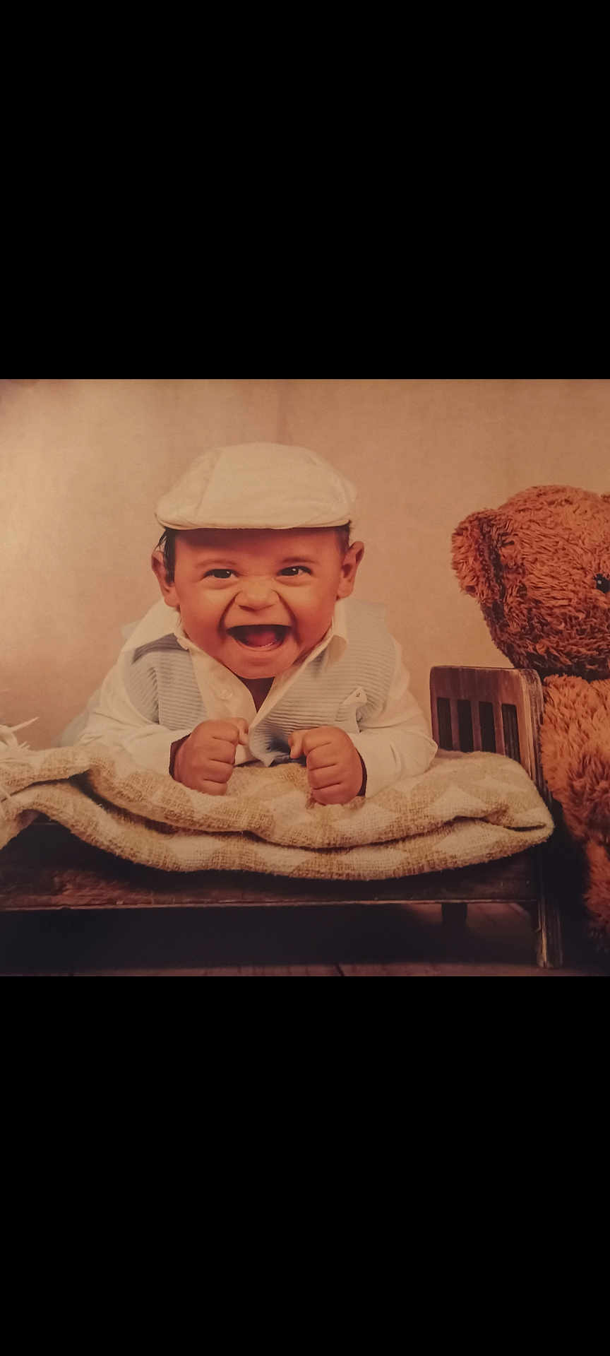 Kaysonn a rejoint le concours — aidez-le/la à gagner de superbes lots ! baby, child, smiling, laughing, cap, vest, blanket, bed, teddy_bear, stuffed_animal, wooden_bed, cute, portrait, indoor, happy, cozy, infant, young_child, clothing, soft_lighting