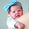 baby, child, headband, blue_bow, infant, portrait, skin, arm, hand, person, cute, expression, closeup, face, newborn, soft_light, indoor, holding, apparel, young