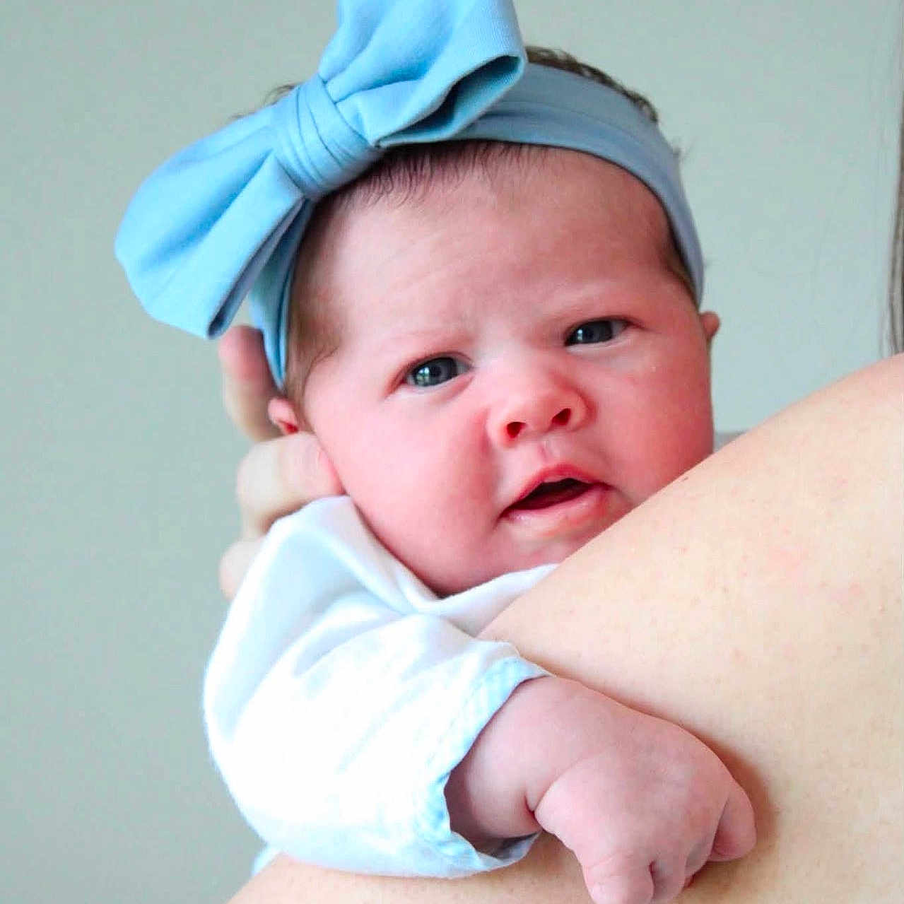 Ella joined the competition — help win amazing prizes! baby, child, headband, blue_bow, infant, portrait, skin, arm, hand, person, cute, expression, closeup, face, newborn, soft_light, indoor, holding, apparel, young