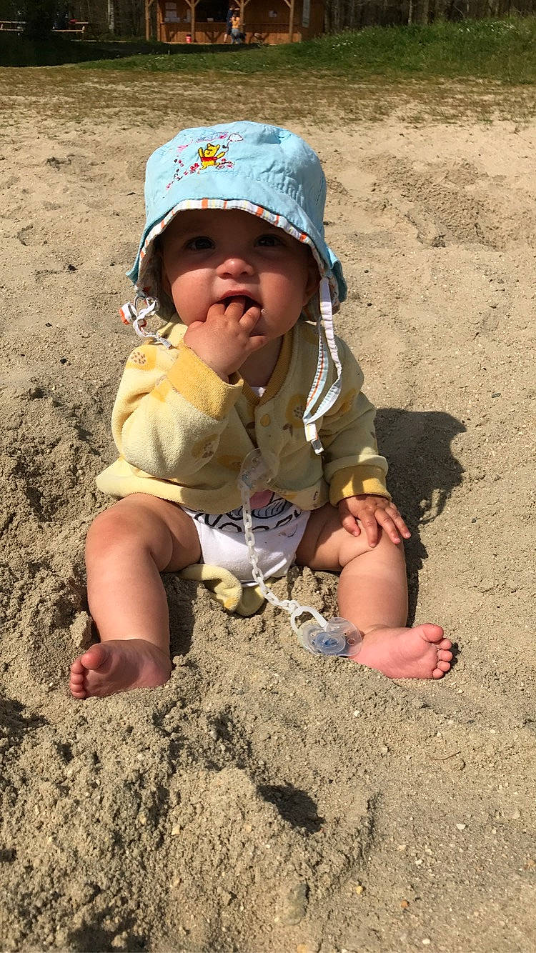 Miya a rejoint le concours — aidez-le/la à gagner de superbes lots ! baby, baby_toddler_clothing, baseball_cap, beach, body_of_water, cap, child, fun, grass, hand, hat, headwear, landscape, people_in_nature, person, personal_protective_equipment, play, sitting, sleeve, soil