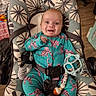 baby, baby_seat, bright_colors, child, cute, expression, floor, happy, indoors, infant, onesie, patterned_fabric, person, playful, plush_toy, seated, smiling, straps, teething_toy, wooden_floor