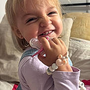 Cyanea participe au concours pour gagner de l'argent avec cette photo : toddler, child, smiling, face, hand, bracelet, pacifier, clothing, denim, overalls, bed, pillow, indoor, happy, cute, playful, light, hair, person, portrait