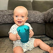 Henry joined the competition — help win amazing prizes! baby, blue_eyes, carpet, child, clothing, couch, cup, cute, furniture, happy, holding, home, indoor, infant, onesie, person, playful, portrait, sitting, smiling