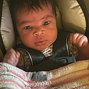 Aria is registered to the contest to win money with this photo: baby, infant, car_seat, blanket, face, child, clothing, person, seatbelt, closeup, indoor, safety_harness, cute, portrait, expression, hands, newborn, young_child, resting, attention