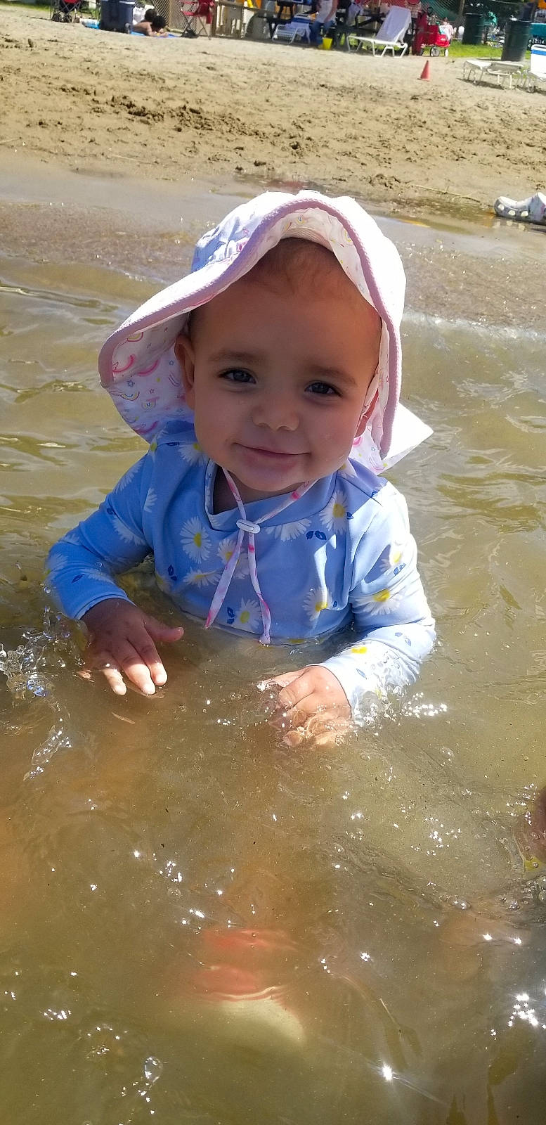Presley is registered to the contest to win money with this photo: baseball_cap, bathing, beach, cap, child, electric_blue, fun, happy, hat, headwear, lake, leisure, person, personal_protective_equipment, play, recreation, smile, toddler, vacation, water