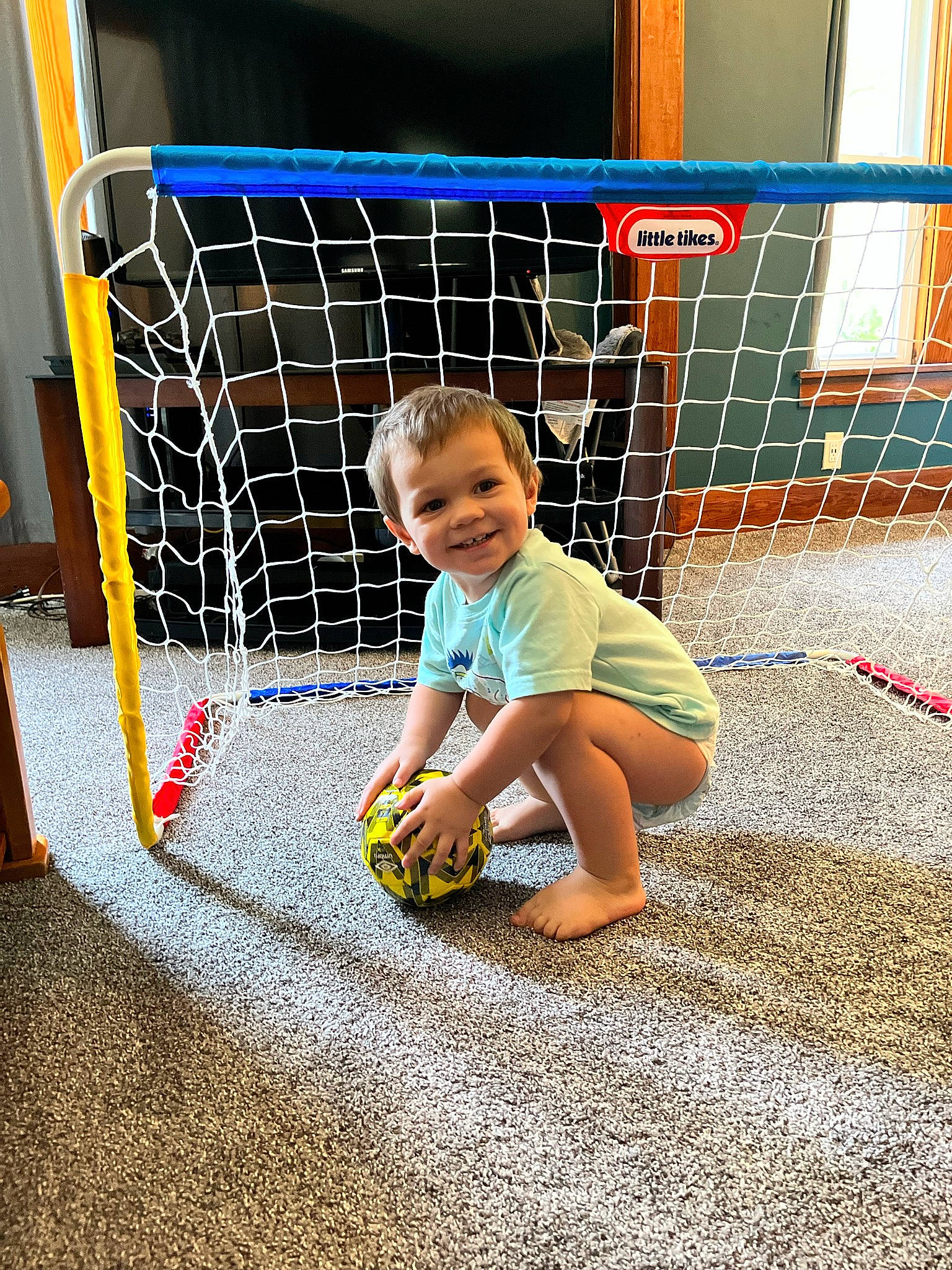 Deven joined the competition — help win amazing prizes! asphalt, baby_toddler_clothing, child, flooring, fun, grass, joy, leisure, mesh, net, pattern, person, play, product, recreation, road_surface, shorts, sitting, smile, soil