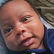 Nasir joined the competition — help win amazing prizes! baby, baby_garment, close_up, clothing, curious, cute, expression, eyes, face, head, indoors, infant, lying_down, navy_blue, person, portrait, skin, smile, soft_texture, young_child