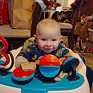 Grace is registered to the contest to win money with this photo: baby, cat, chair, child, clothing, colorful, cute, face, floor, furniture, happy, home, indoor, infant, person, pet, play, smiling, toy, walker