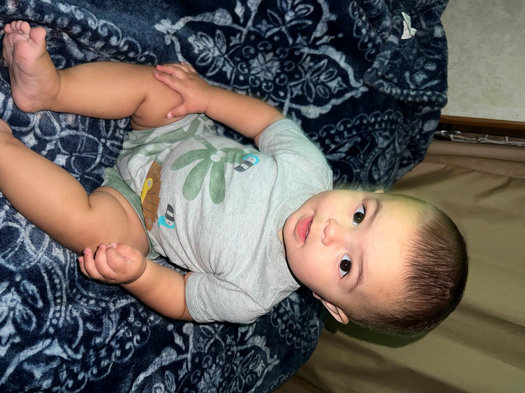 Liam Lewis is registered to the contest to win money with this photo: baby, baby_toddler_clothing, cheek, child, comfort, couch, fun, grass, human_leg, joint, pattern, person, room, shorts, sitting, skin, t_shirt, textile, thigh, toddler