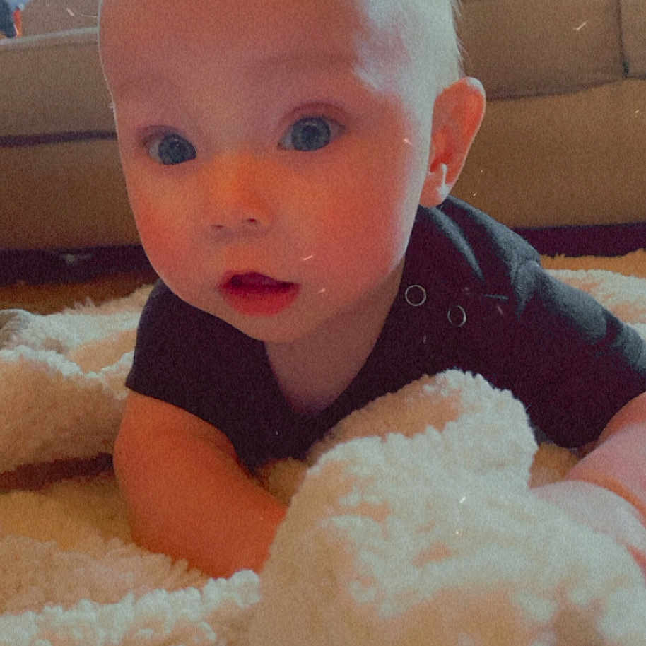 Franklin is registered to the contest to win money with this photo: baby, blanket, carpet, child, clothing, couch, cozy, curtains, cute, expression, face, furniture, home, indoor, infant, lying_down, person, portrait, soft_texture, young_child