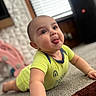 baby, blinds, blurred_background, bracelet, bright_clothing, carpet, child, crawling, cute, expression, face, home, indoor, infant, onesie, person, playful, smiling, tongue_out, window
