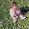 Maÿana participe au concours pour gagner de l'argent avec cette photo : baby, child, clapping, cute, daisy, daytime, flower, grass, grass_field, greenery, hair_accessory, happy, nature, outdoor, pink_clothing, playful, shoes, sitting, sunlight, toddler