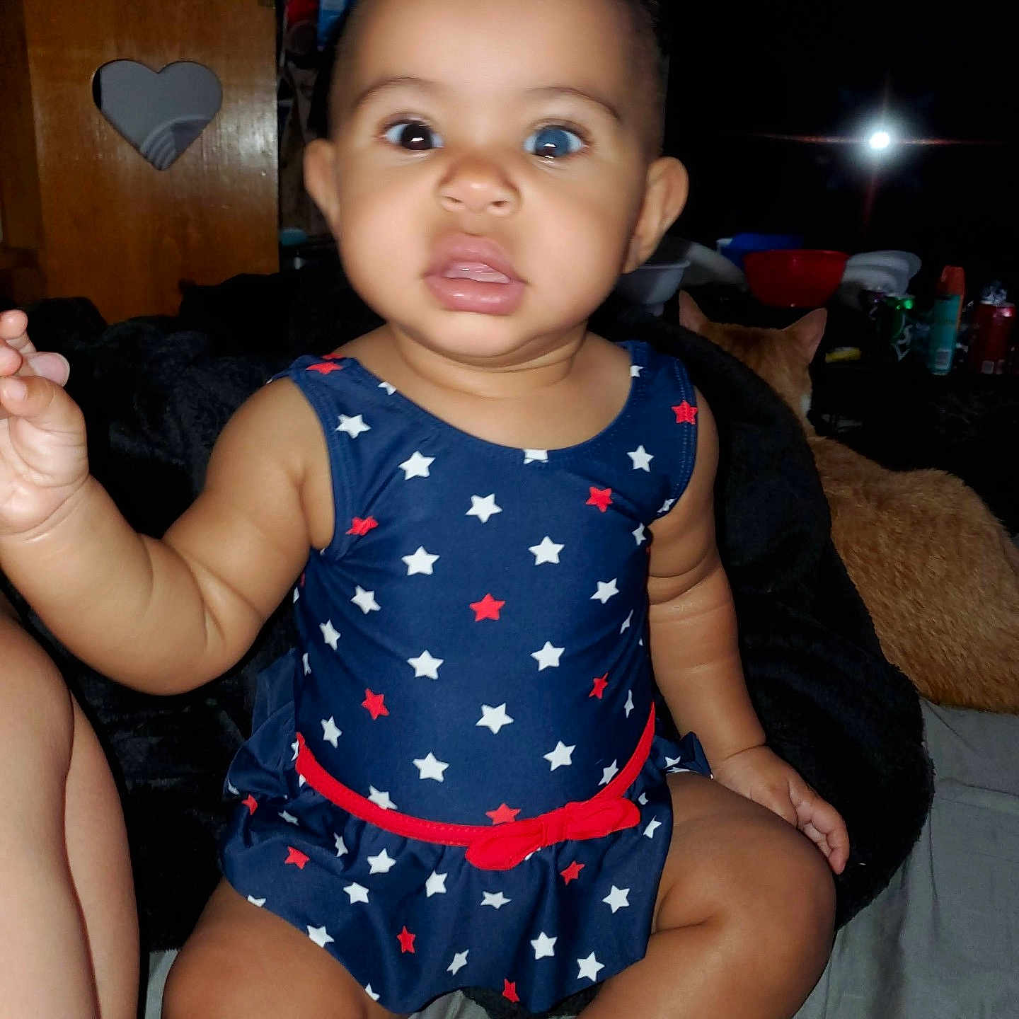 Emiko is registered to the contest to win money with this photo: baby, bed, blanket, blue_dress, cat, child, cute, dress, expression, eyes, face, furniture, hair, indoor, infant, person, red_bow, sitting, skin, stars