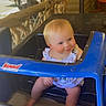 baby, blonde_hair, blue, child, clothing, cute, daylight, happy, infant, outdoor, person, play, porch, seat, smiling, steering_wheel, summer, toddler, toy_car, wooden_railing