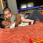 Kye joined the competition — help win amazing prizes! baby, child, bed, blanket, couch, cute, expression, face, furniture, gaming_chair, indoor, person, play, portrait, room, smile, socks, television, toy, young