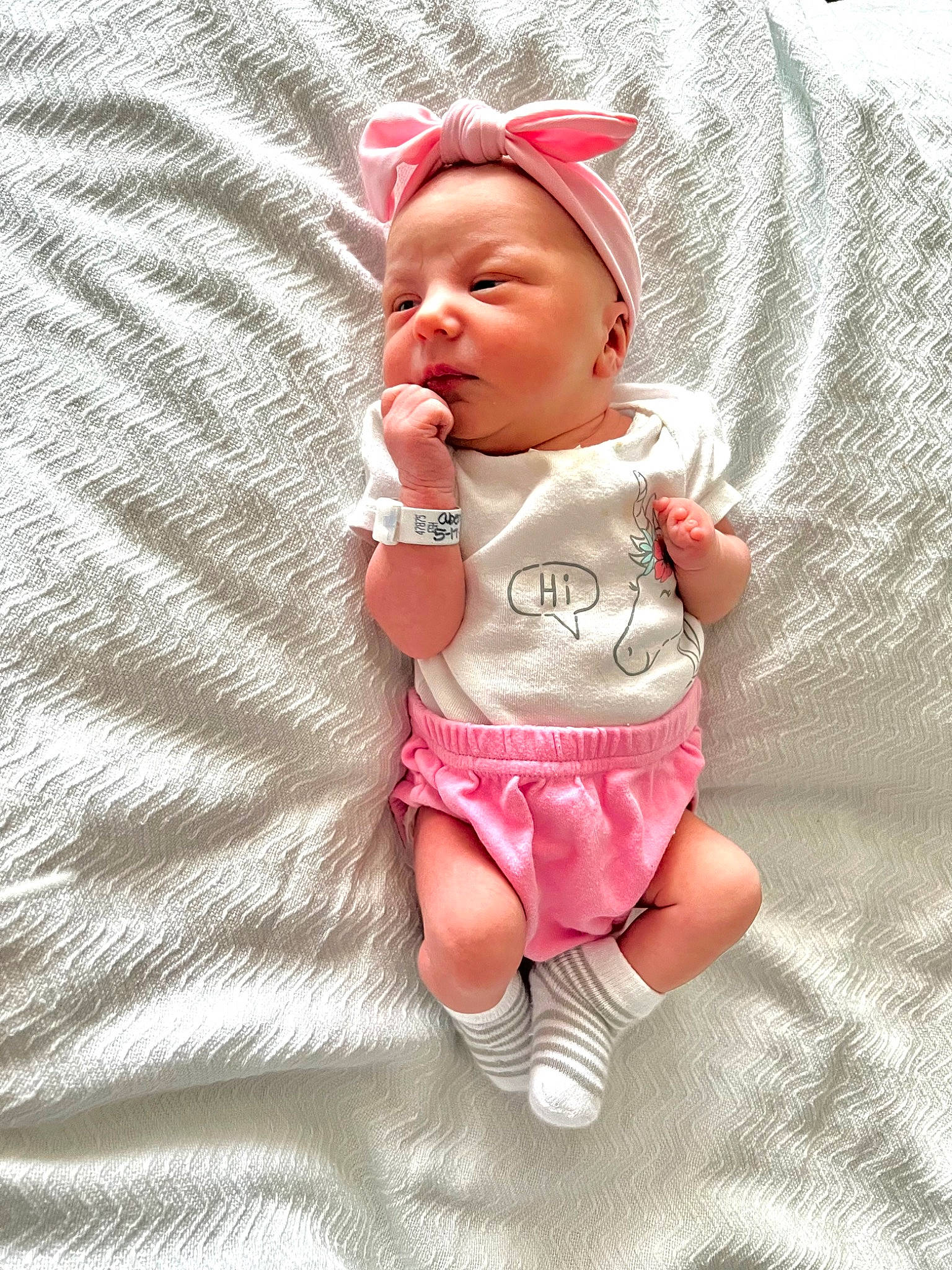 Marlee is registered to the contest to win money with this photo: baby, baby_toddler_clothing, cap, cheek, comfort, eye, finger, foot, glasses, happy, human_body, lip, pattern, person, pink, skin, sleeve, sock, t_shirt, textile