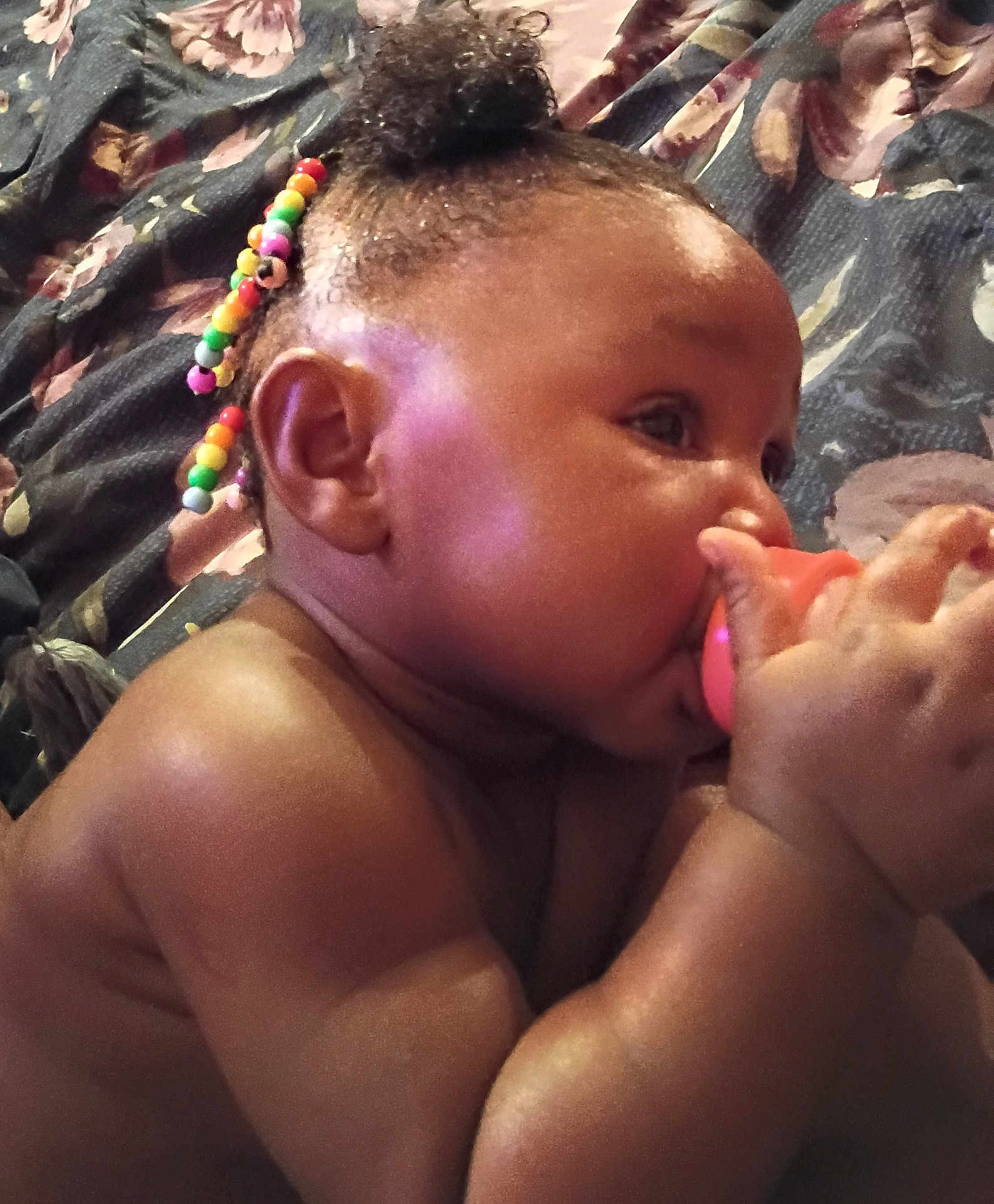 Zadie is registered to the contest to win money with this photo: baby, child, pacifier, beads, hair, skin, hand, face, ear, blanket, floral, comfort, closeup, cute, infant, portrait, lying_down, indoors, colorful, soft