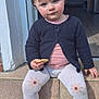 toddler, child, cookie, sitting, steps, outdoor, cardigan, pink_shirt, white_leggings, flower_pattern, white_shoes, sunlight, home_interior, doorway, floor_tiles, cute, serious_expression, young_child, casual_clothing, daylight