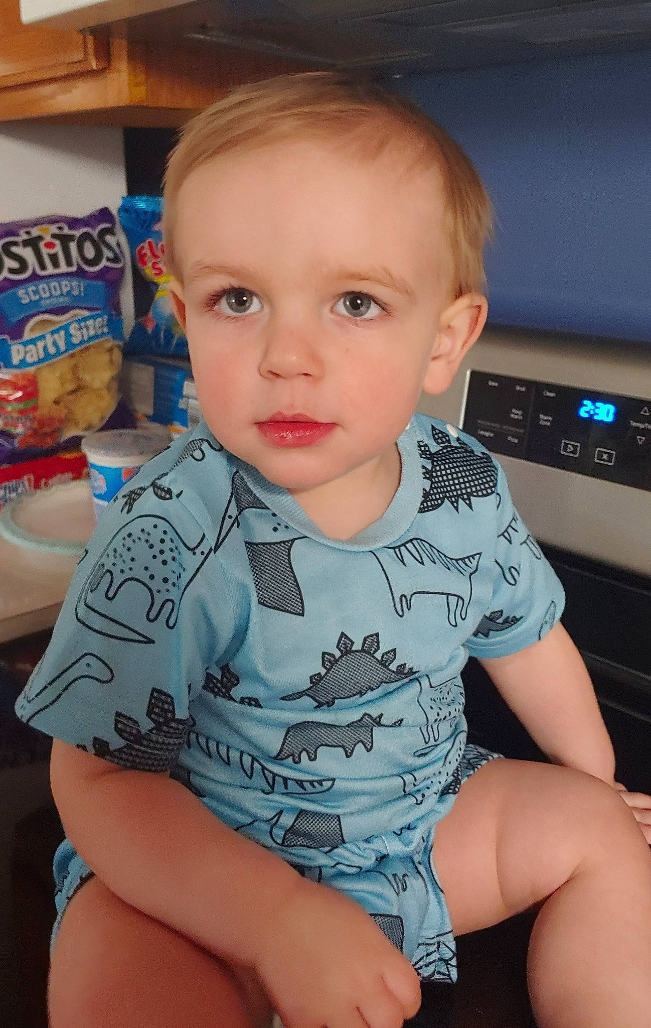 Luca is registered to the contest to win money with this photo: baby, baby_toddler_clothing, blond, cheek, child, chin, eye, eyelash, finger, fun, happy, iris, lap, nose, person, sitting, skin, sleeve, t_shirt, toddler