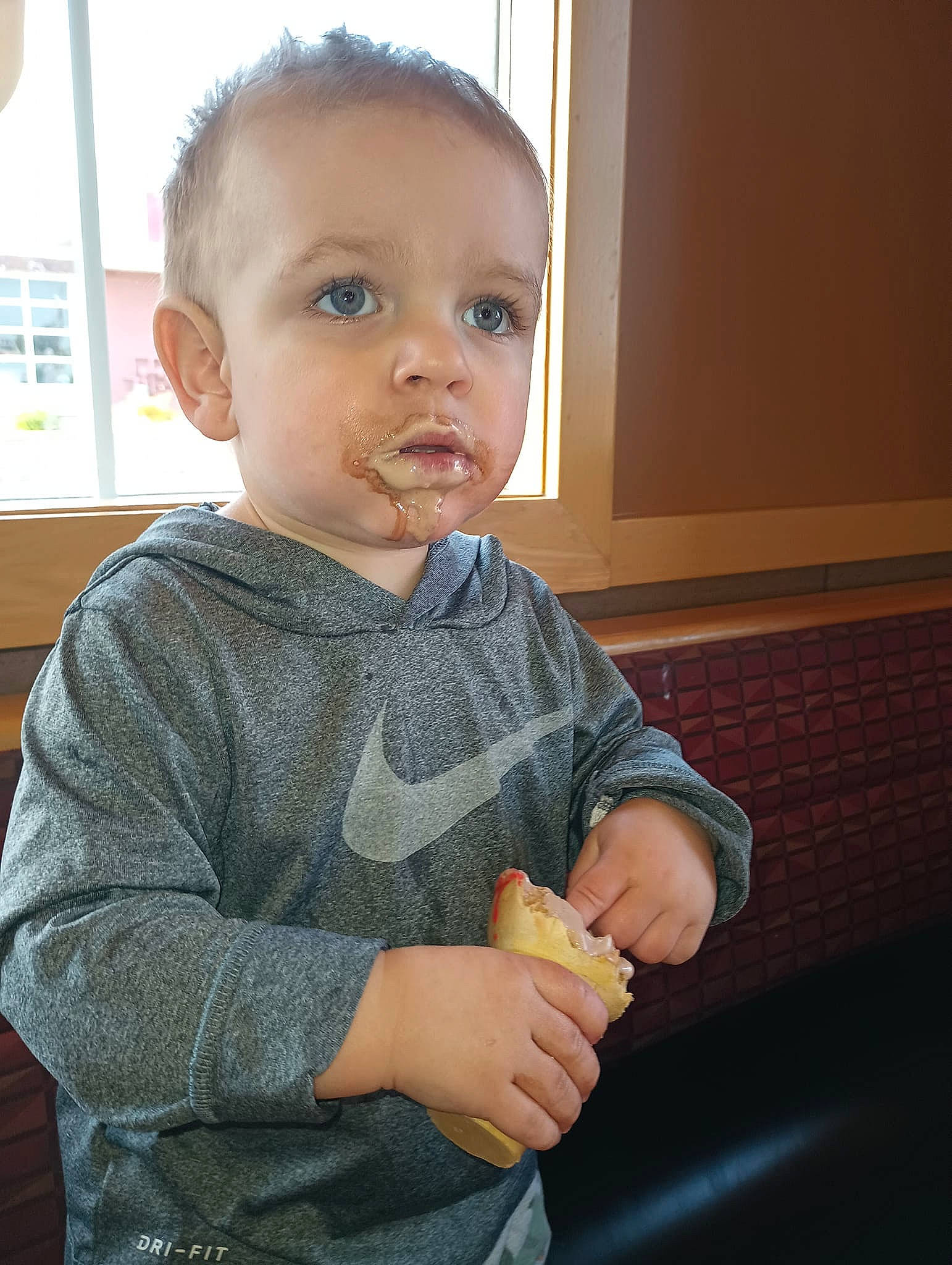 Luca is registered to the contest to win money with this photo: arm, baby, baby_toddler_clothing, cheek, child, elbow, finger, gesture, nail, nose, person, sitting, skin, sleeve, t_shirt, thumb, toddler, wrist