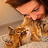 Gracy participe au concours pour gagner de l'argent avec cette photo : woman, cat, tabby_cat, close_up, affection, pet, indoor, cozy, fur, face, whiskers, eyelashes, cuddle, warm_light, soft_texture, human_animal_bond, relaxation, compassion, home, comfort