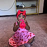 bottle, carpet, child, cute, drinking, electronics, entertainment, floor, furniture, girl, headband, home, indoor, pink_dress, red_bow, sitting, television, toddler, toy, young_child