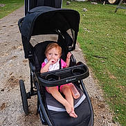 Annabelle is registered to the contest to win money with this photo: baby, barefoot, bottle, cabin, campground, child, family_outing, grass, jogging_stroller, nature, outdoor, path, pink_clothing, playground, portrait, sitting, smiling, stroller, toddler, tractor