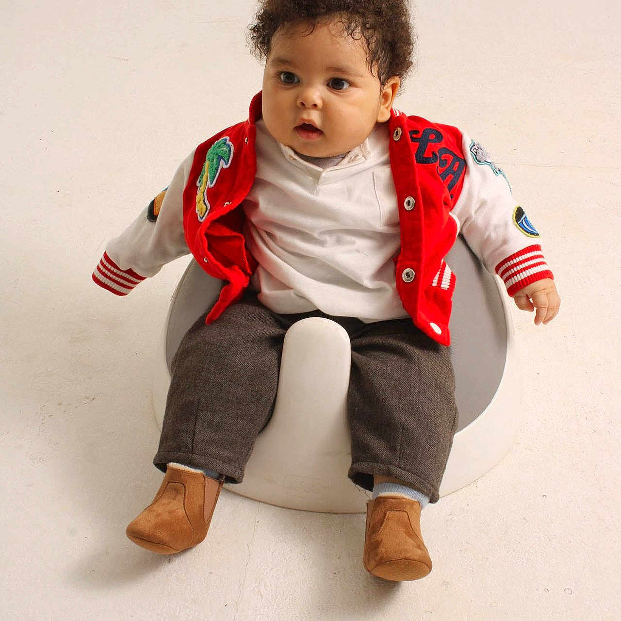 Aderinmade Axel is registered to the contest to win money with this photo: baby, bathroom, bodypart, chair, clothing, coat, face, footwear, furniture, head, indoors, jacket, pants, person, photography, portrait, room, shoe, sitting, toilet